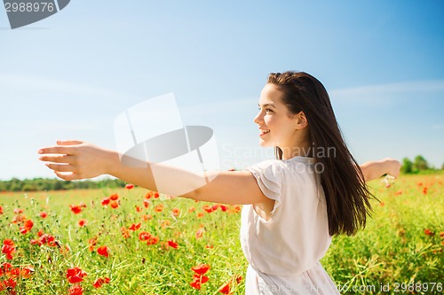 Image of smiling young woman on poppy field