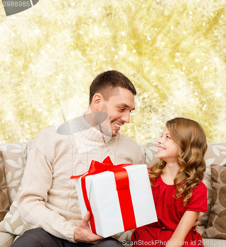 Image of smiling father and daughter with gift box