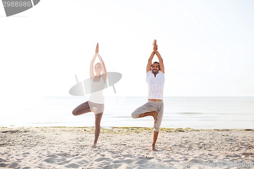 Image of couple making yoga exercises outdoors