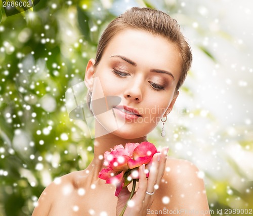 Image of woman with diamond earrings, ring and flower