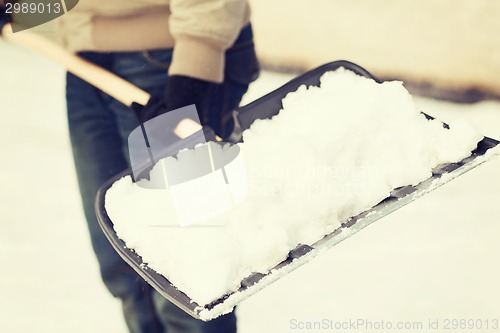 Image of closeup of man shoveling snow from driveway