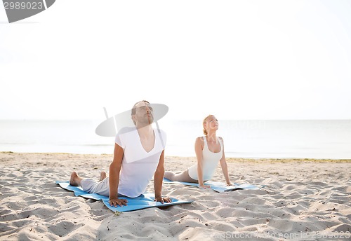 Image of couple making yoga exercises outdoors