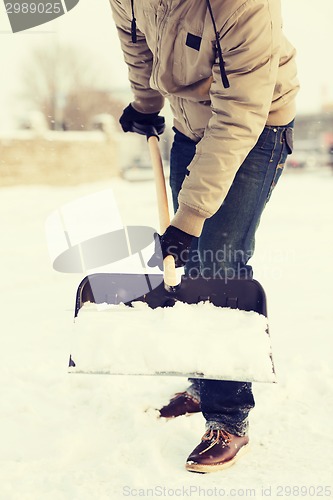 Image of closeup of man shoveling snow from driveway