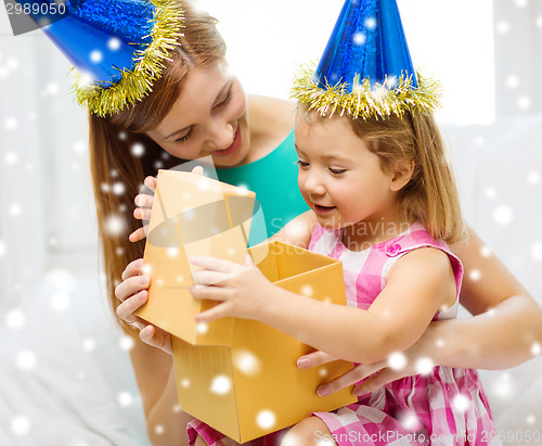 Image of mother and daughter in party hats with gift box