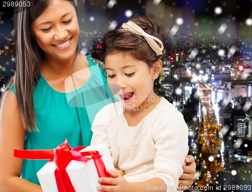 Image of happy mother and little girl with gift box