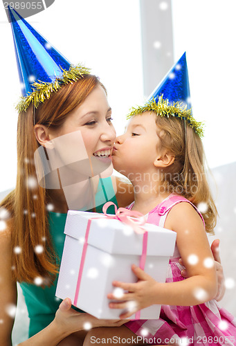 Image of mother and daughter in party hats with gift box