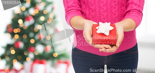 Image of close up of woman in pink sweater holding gift box