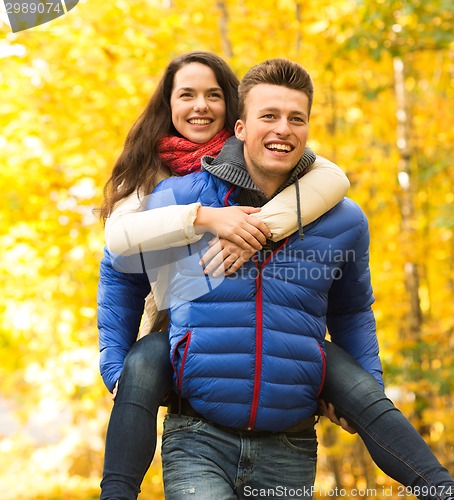 Image of smiling couple having fun in autumn park