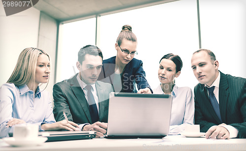 Image of business team with laptop having discussion