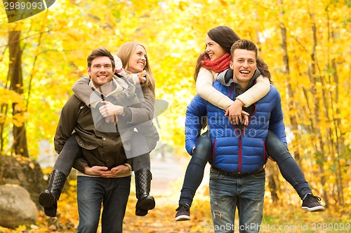 Image of smiling friends having fun in autumn park