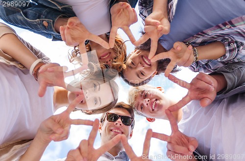 Image of group of teenagers showing finger five