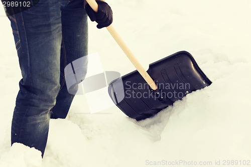 Image of closeup of man shoveling snow from driveway