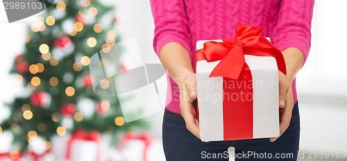 Image of close up of woman in pink sweater holding gift box