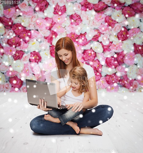 Image of happy mother with little girl and laptop