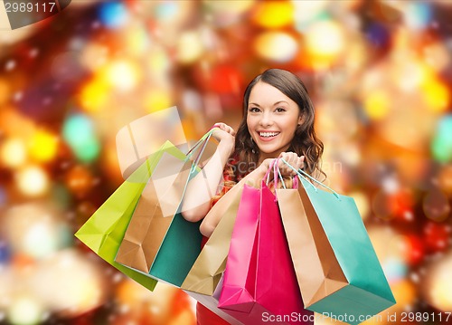 Image of smiling woman with colorful shopping bags