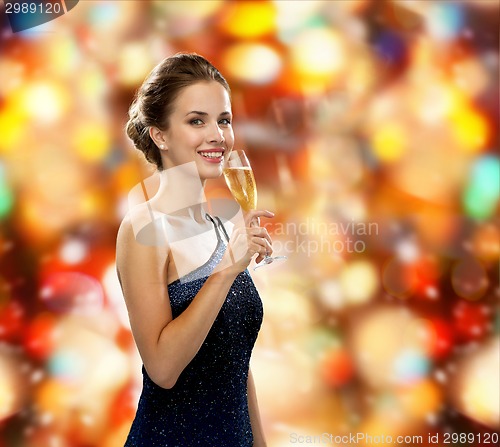 Image of smiling woman holding glass of sparkling wine