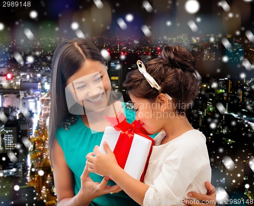 Image of happy mother and little girl with gift box