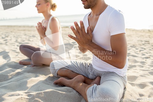 Image of close up of couple making yoga exercises outdoors