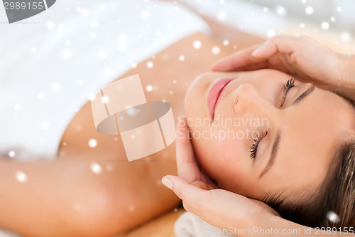 Image of beautiful woman getting face or head massage