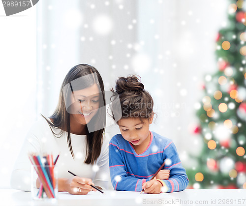 Image of mother and daughter with coloring pencils indoors