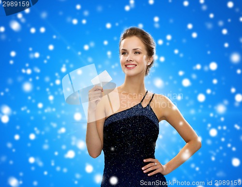 Image of smiling woman in evening dress holding credit card
