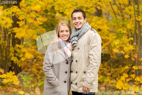 Image of smiling couple hugging in autumn park