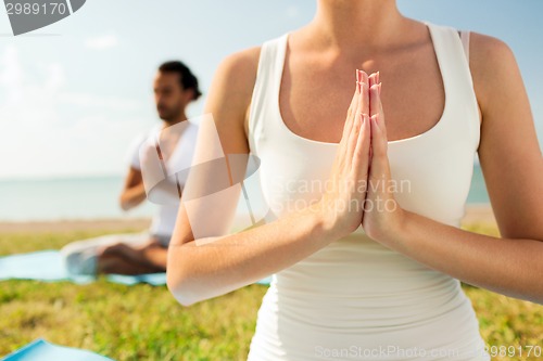 Image of close up of couple making yoga exercises outdoors