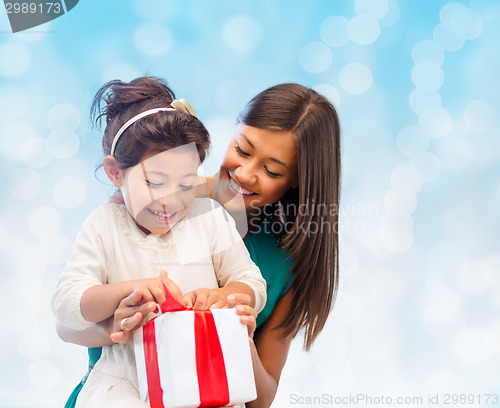 Image of happy mother and little girl with gift box