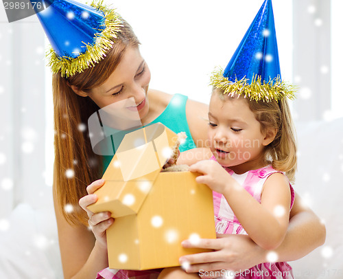 Image of mother and daughter in party hats with gift box