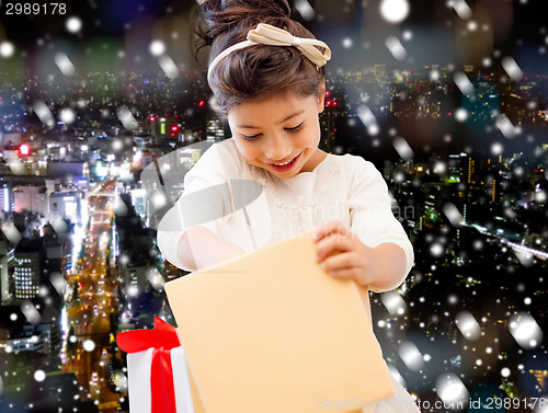 Image of smiling little girl with gift box