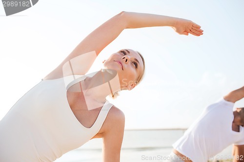 Image of close up of couple making yoga exercises outdoors