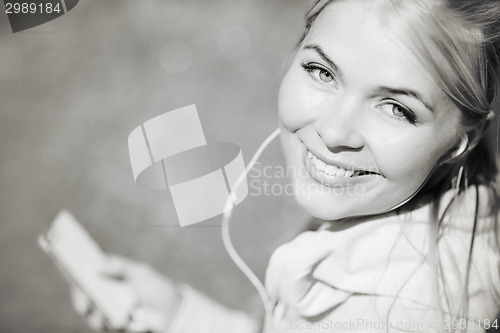 Image of woman listening to music outdoors