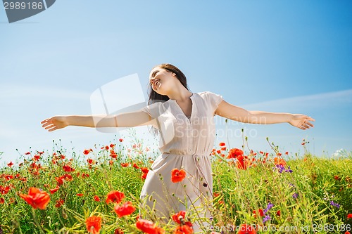 Image of smiling young woman on poppy field