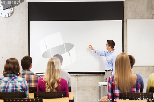 Image of group of students and smiling teacher in classroom