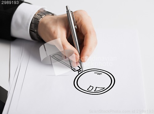 Image of close up of male hand with pen drawing graph