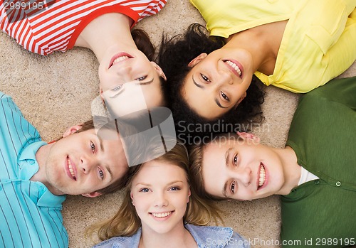Image of group of smiling people lying down on floor