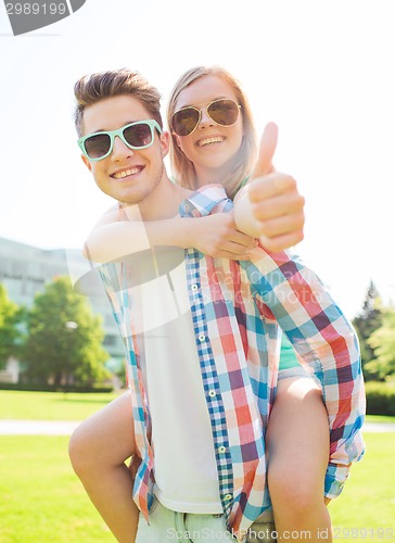 Image of smiling couple having fun and showing thumbs up