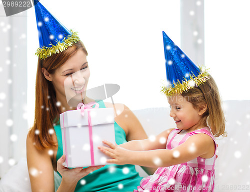 Image of mother and daughter in party hats with gift box