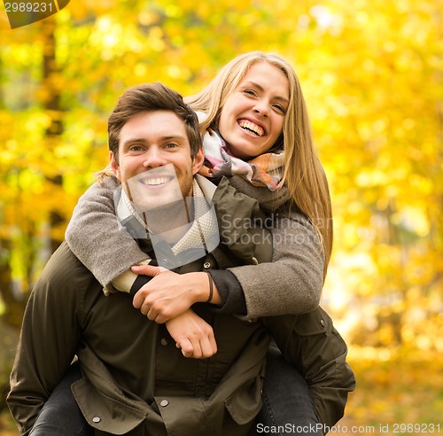 Image of smiling couple having fun in autumn park