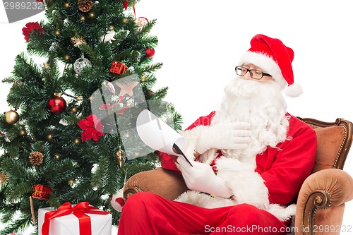 Image of man in costume of santa claus with notepad