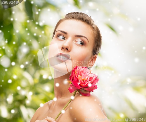 Image of woman with diamond earrings, ring and flower