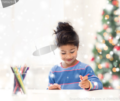 Image of smiling little girl with pencils drawing at home