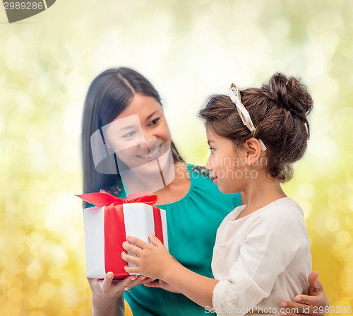 Image of happy mother and child girl with gift box