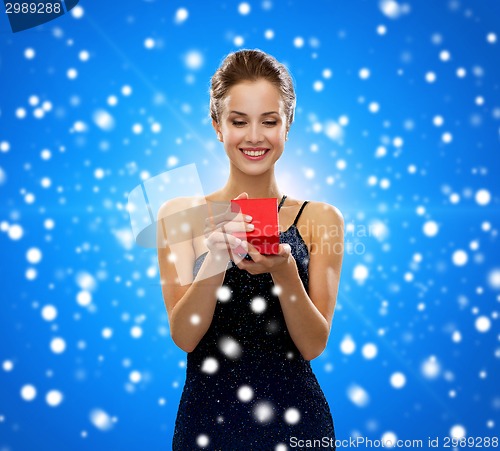 Image of smiling woman holding red gift box