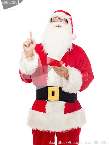 Image of man in costume of santa claus with notepad