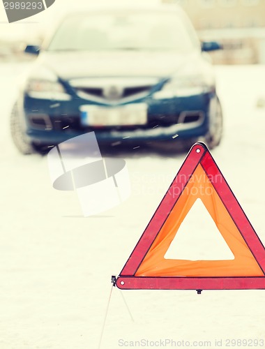 Image of closeup of warning triangle and car