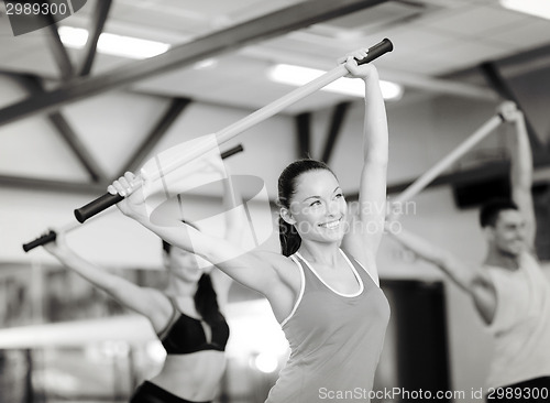 Image of group of smiling people working out with barbells