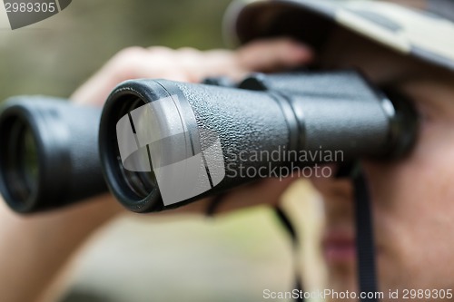 Image of close up of soldier or hunter with binocular