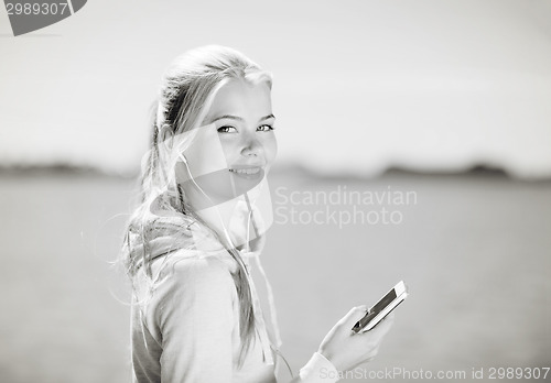 Image of woman listening to music outdoors