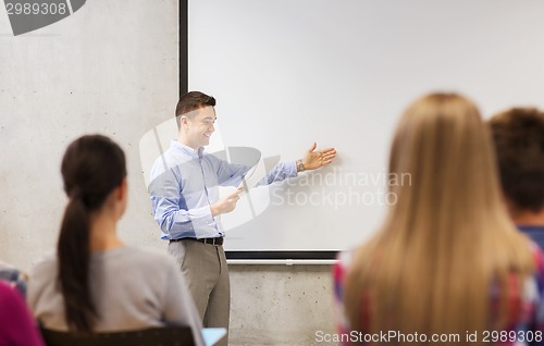 Image of group of students and smiling teacher with notepad